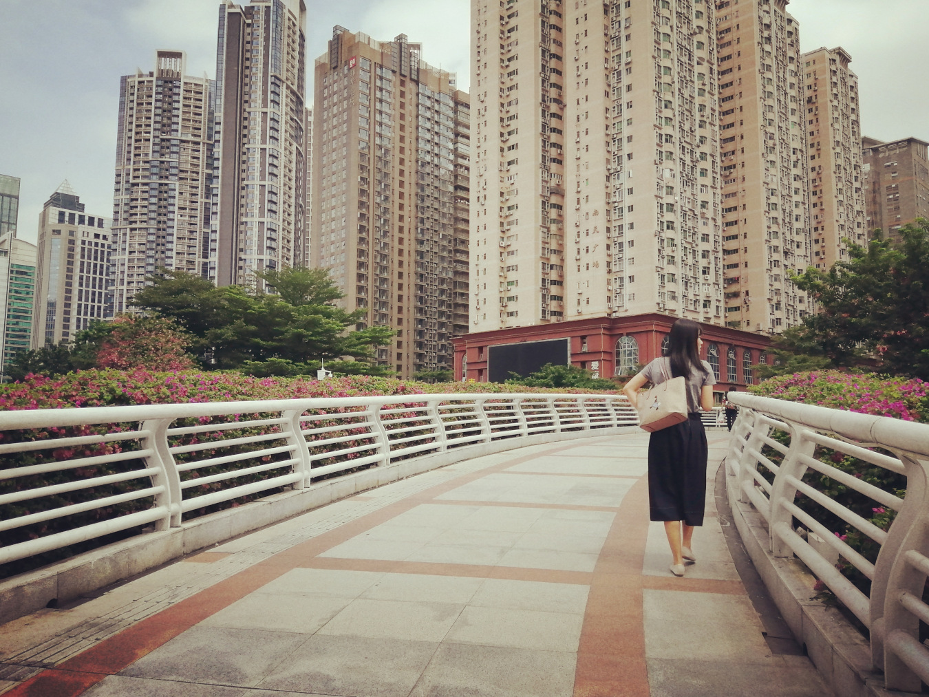 woman walking overpass buildings