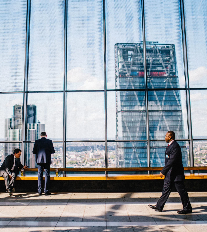 man in suit walking skyscraper in the background
