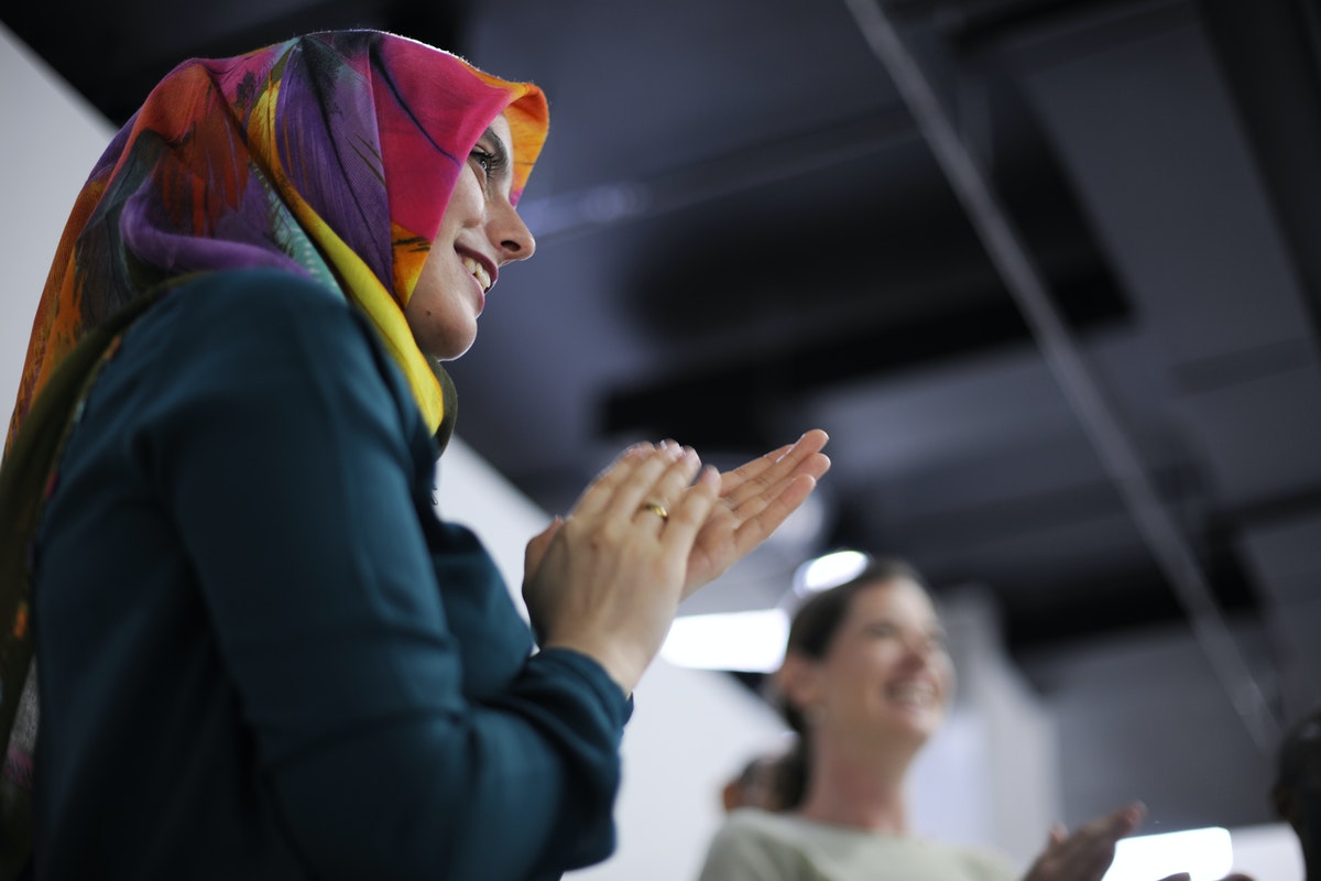 woman in red headdress clapping