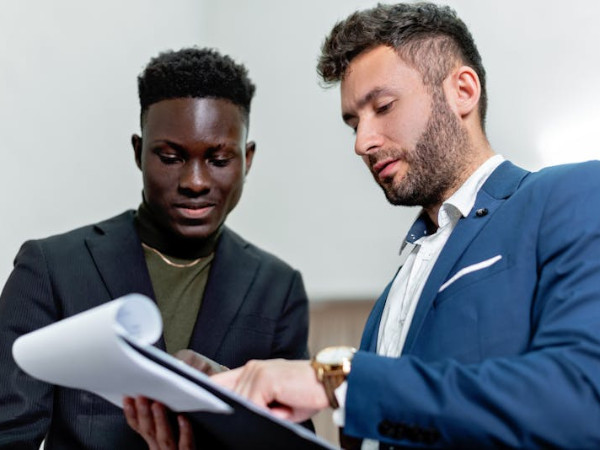 2 people in suits holding clipboard training