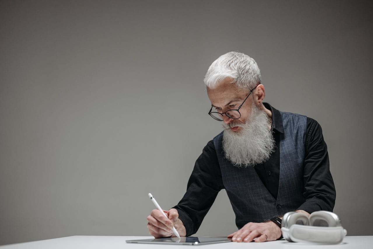 A Bearded Businessman Drawing on a Tablet with a Stylus